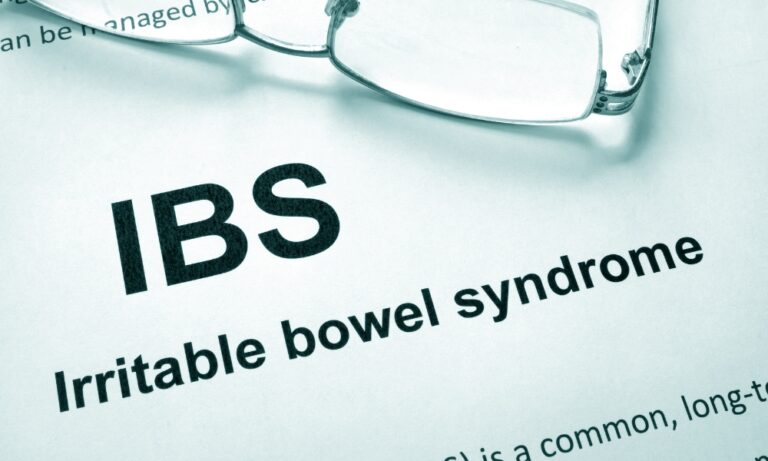 Irritable bowel syndrome (IBS) text with reading glasses