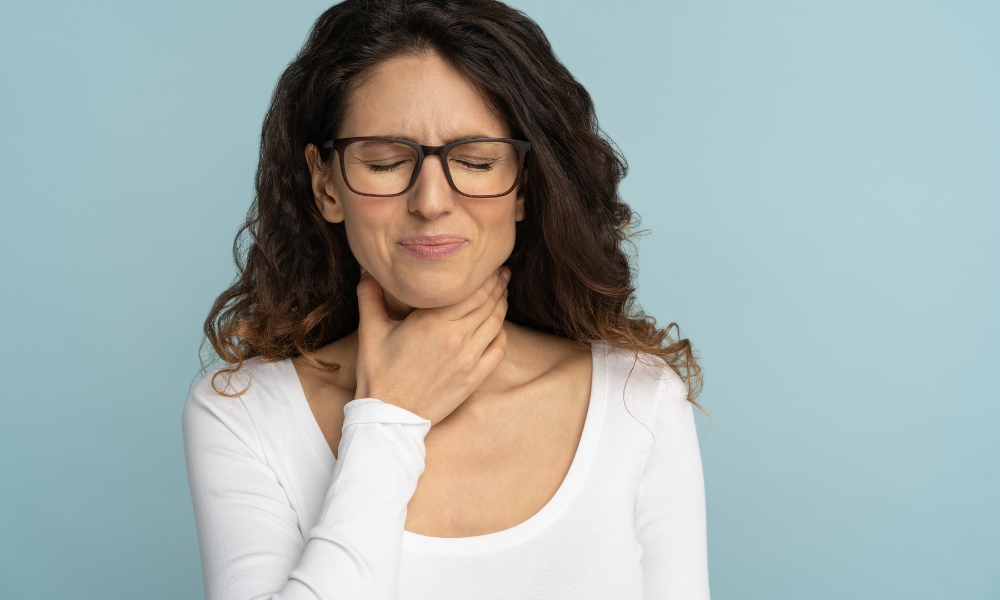 Gastroenterologist explaining difficulty swallowing and dysphagia evaluation to a patient using an esophagus illustration